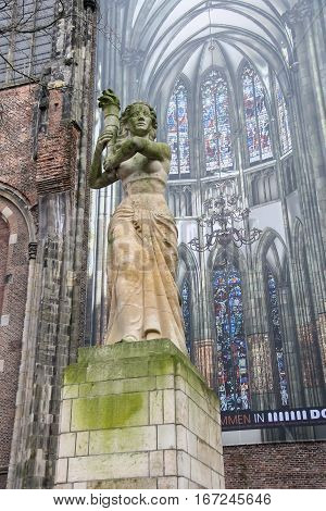 Utrecht the Netherlands - February 13 2016: Figure of the woman with a torch near St. Martins Cathedral (Domkerk)