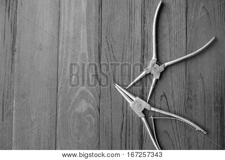 Pliers for remove the snap ring Pliers on black wood