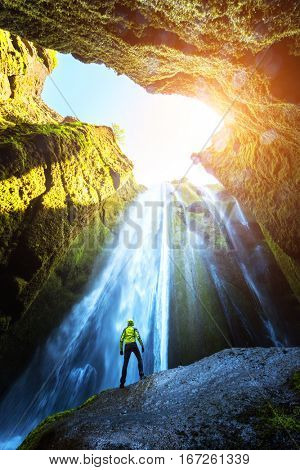 Man in the cave near the Gljufrabui waterfall, Iceland, Europe