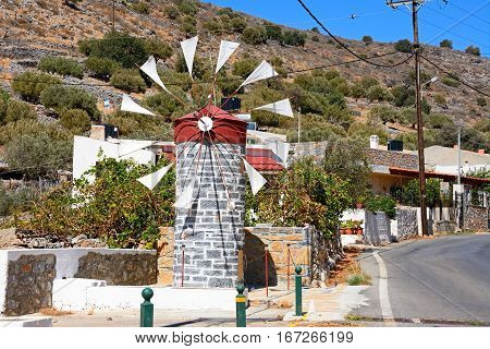 ELOUNDA, CRETE - SEPTEMBER 17, 2016 - Small stone windmill along a village street near Elounda Crete Greece Europe, September 17, 2016.