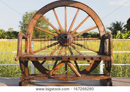 Wood Chair Decorated With Cart Wheel On Terrace In Sunhemp Pummelo Flower Filed