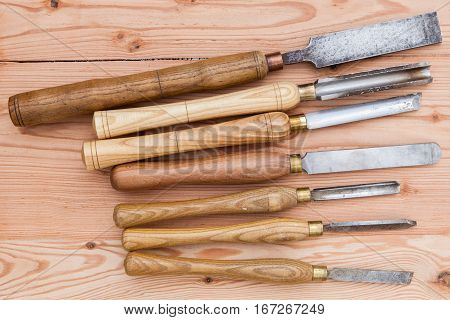Old used wood lathe chisels selection on the wooden table selective focus