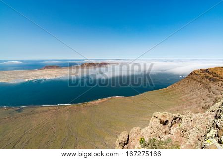 View on the volcanic coastline and Isla Graciosa from Mirador del Rio vista Lanzarote Spain