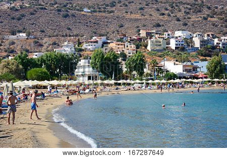 ELOUNDA, CRETE - SEPTEMBER 17, 2016 - View along the beach and coastline with tourists relaxing in the sunshine Elounda Crete Greece Europe, September 17, 2016.