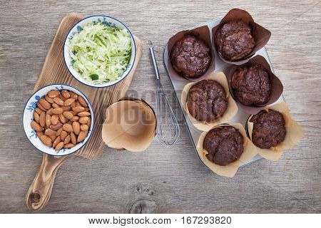 Flourless chocolate courgette muffins in a muffin tin on a wooden table
