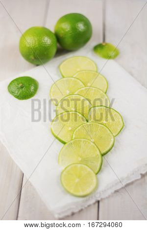 Cut slices of lime on white paper.