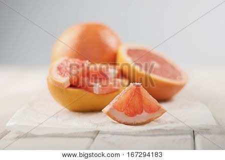 Sliced grapefruit with a paper and a half in the background.