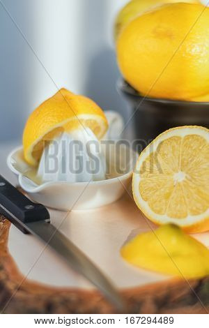 Cut lemon with knive on a wooden board.