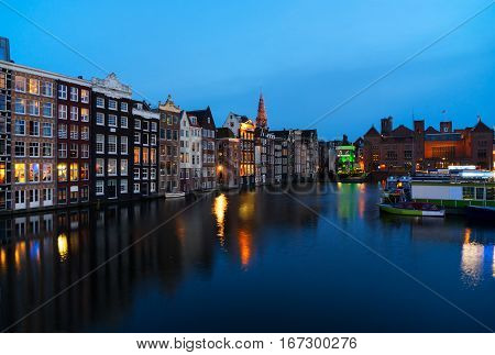 Houses over canal with mirror reflections at blue night, Amstardam, Netherlands