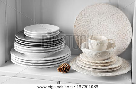 Different clean dishes in cupboard in the kitchen