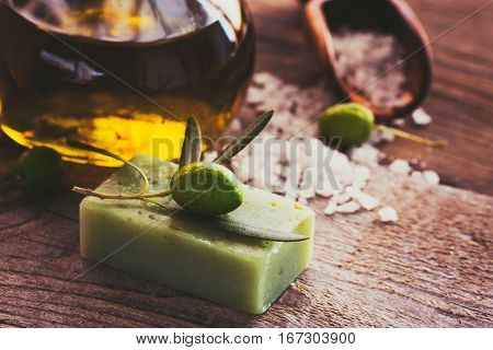 Natural spa setting with olive and olive oil products: bath salt natural soap and olive oil.