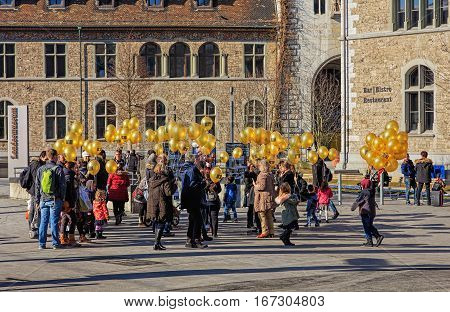 Zurich, Switzerland - 29 January, 2017: a group of people with balloons bearing the symbolic of the C3 Church on the square at the entrance to the Swiss National Museum.