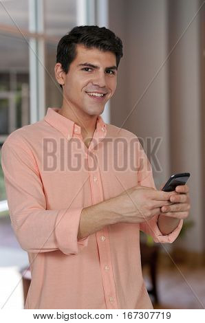 Handsome man using a cell phone for texting