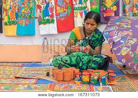 Kolkata West Bengal India - 28th November 2015 : Woman hand coloring pen stands made of clay handicrafts on display during the Handicraft Fair in Kolkata. Biggest handicrafts fair in Asia.