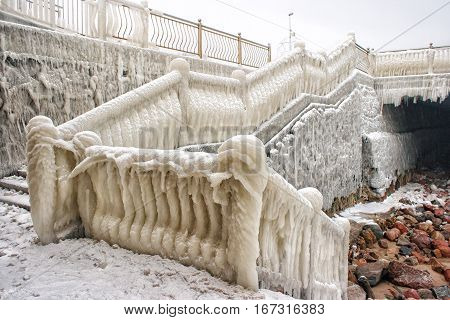 ice covered staircase on the beach on cold gloomy winter day