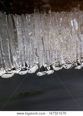 Icicles Above Freeze Winter Mountain Stream. Winter Season At River