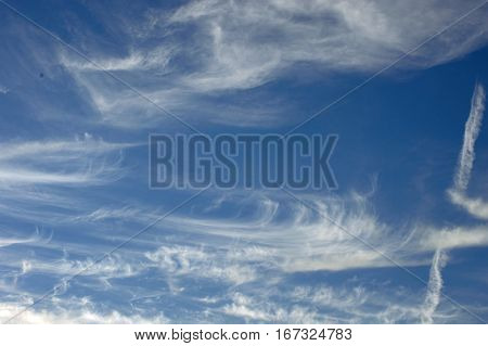 White clouds whisp across a beautiful clear blue sky