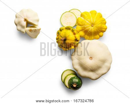 Yellow, white and green zucchini, courgette and round pattipan squashes isolated on white background. Sorts of sliced cucurbit top view