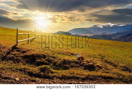 Fence On Rural Field In Spring At Sunset