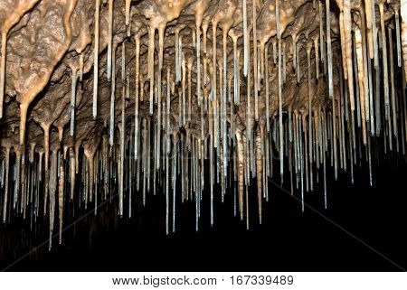 Many thin stalactites on the ceiling of the cave Kinderlinskaya. Russia Ural.