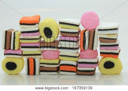 Stacked liquorice allsorts in different shapes colors and sizes