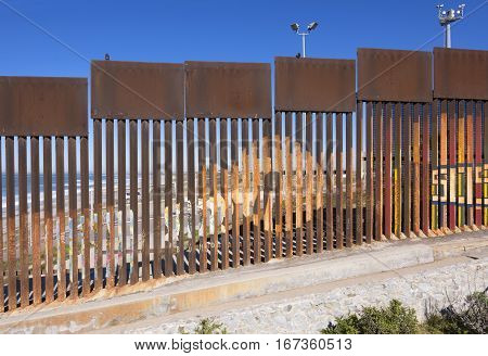 Steel fence made of vertical girders separating Mexico from the United States in a secured political boundary in Playas de Tijuana in Mexico