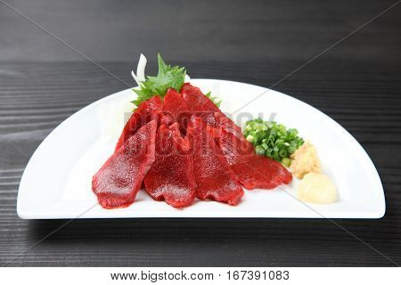 studio shot of horse meat sashimi on a table