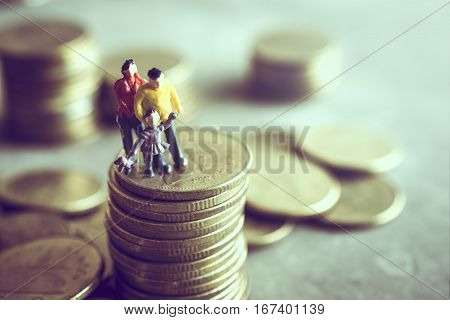 Miniature Mum Dad And Kids Standing On Top Of The Money Save Money Concept.