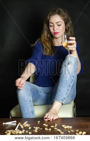 Dissapointed woman sitting on chair with glass of wine