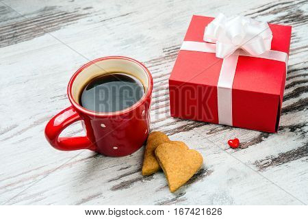 two red coffee cup, hearts cokies and gift box on wooden surface. Valentines day concept.