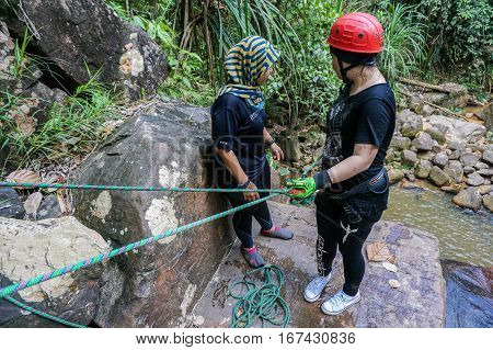 Beaufort,Sabah,Malaysia-Jan 28,2017:Group of canyoneer get ready to abseil down a waterfall in Beaufort,Sabah,Borneo.Waterfall Abseiling activity adventure getting famous in Sabah,Malaysia.