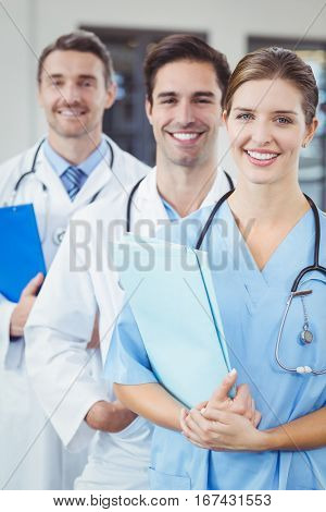 Portrait of happy docors standing in row at hospital