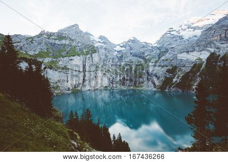 Glacier pond Oeschinensee. Popular tourist attraction. Picturesque and gorgeous scene. Location Swiss alps, Kandersteg, Bernese Oberland, Europe. Vintage effect. Instagram filtered. Beauty world.