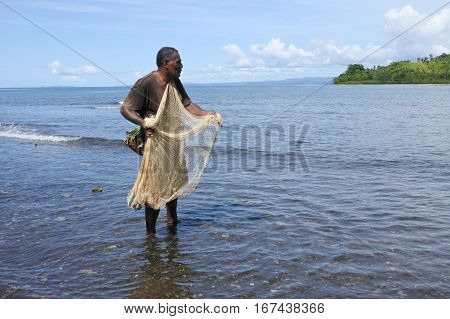 Indigenous Fijian Fisherman Fishing With A  Fishing Net In Fiji