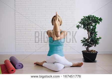 young girl in a blue t-shirt doing yoga at home. wellness concept