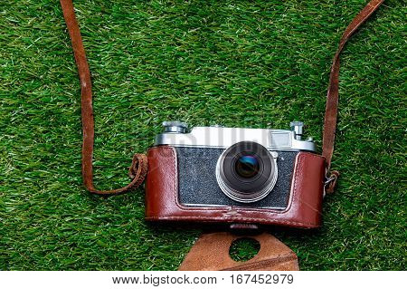 Vntage Camera In Case On Spring Green Grass Background