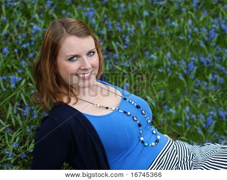 glad ung kvinde midt i blomster