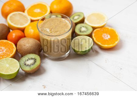 Smothie rich in vitamin C made with oranges lemons limes clementines kiwis; copy space for text; selective focus