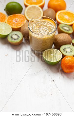 Smothie rich in vitamin C made with oranges lemons limes clementines kiwis; copy space for text; selective focus