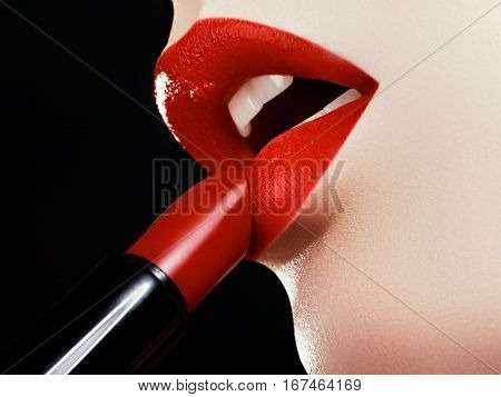 Cosmetics And Makeup. Perfect Lip Makeup. Fashion Model Applying Lipstick. Beautiful Young Woman