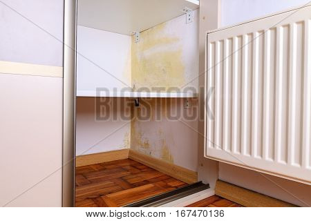 Persistent mold on wall in wardrobe and shelves. Hanging heater near the corner.