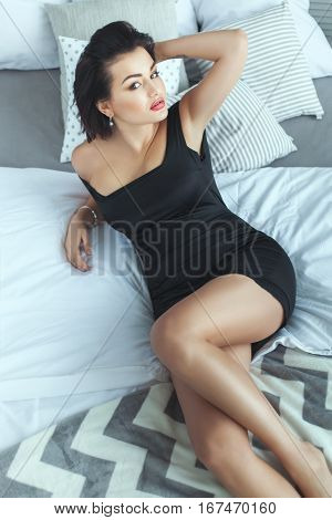 Beautiful sexy woman lying on the bed in the room.