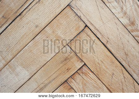 Close top view on vintage parquet floor with geometric mosaic of wood pieces used for decorative effect. Wood block patterns for flooring in herringbone mosaic