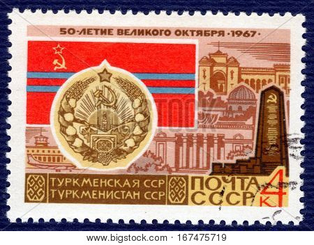 USSR - CIRCA 1967: post stamp printed in the USSR shows Coat of Arms, Flag and monument Turkmen SSR, serie 