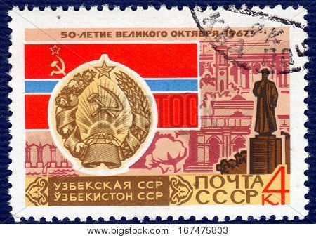 USSR - CIRCA 1967: post stamp printed in the USSR shows Coat of Arms, Flag and monument Uzbek SSR, serie 
