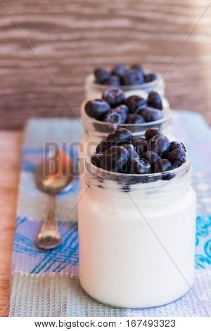Homemade yogurt with blueberries in a glass jar