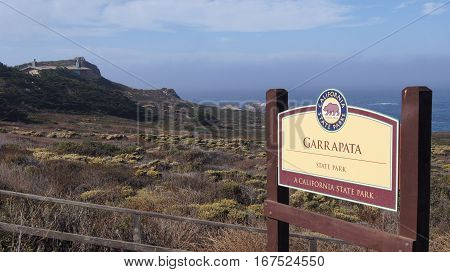 BIG SUR, CALIFORNIA, UNITED STATES - OCT 7, 2014: Hiking path along the Pacific Ocean in Garrapata State Park, closeup of the official entry sign.