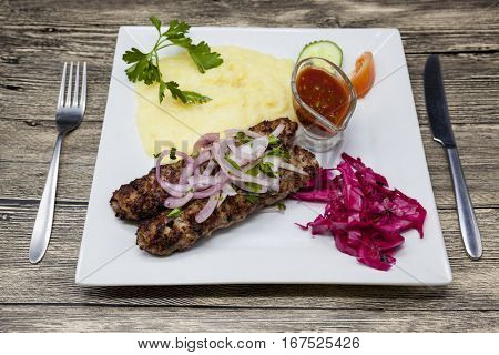 Lula kebab.Traditional Oriental dish, barbecue on fire shish kebab. Cutlets of lamb, onions, cabbage, mashed potatoes spicy tomato sauce.