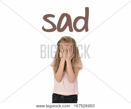 English language learning vocabulary school card with word sad and sweet young little schoolgirl covering her face with her hands crying sad victim of bullying at school isolated on white