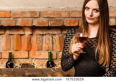 Woman Tasting Wine In Rural Cottage Interior